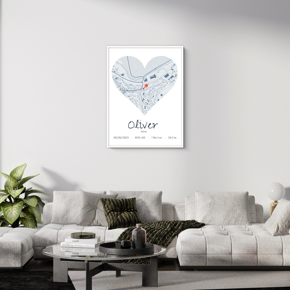 White-framed birth stats poster with a heart-shaped city map above a light gray sofa