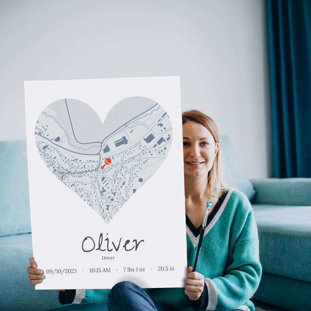 Personalized baby gift: unframed heart-shaped city map print with birth details in front of a blue sofa