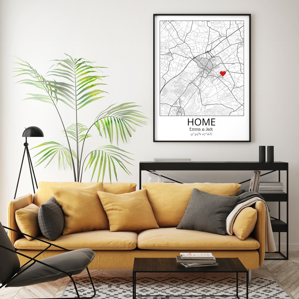 Personalized home map with a red heart in a black frame above a yellow couch, a thoughtful housewarming gift