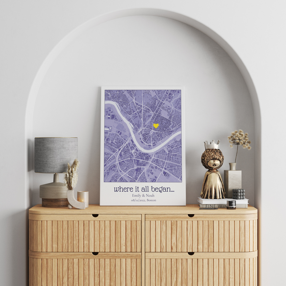 Personalized purple city map print with a yellow heart on a wooden dresser beneath an arched wall niche